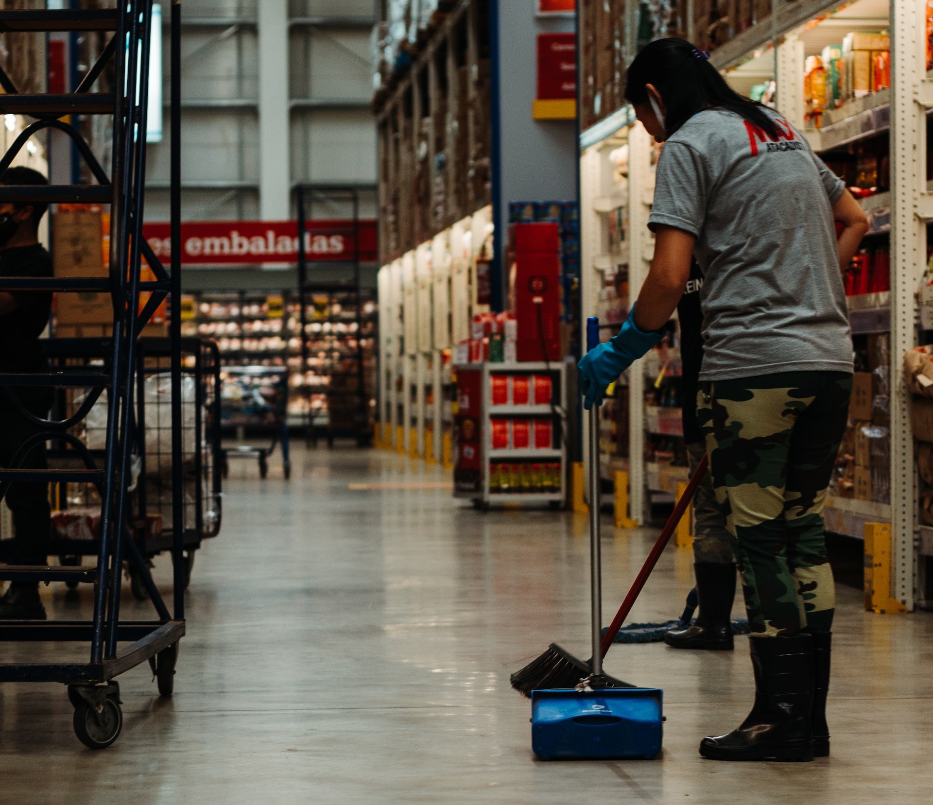 Worker cleaning their warehouse section.