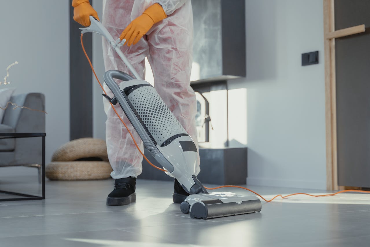 cleaner in full PPE cleaning a workplace 
